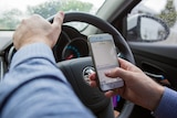 Woman uses her phone while driving.