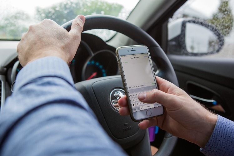 Person using a phone while driving.