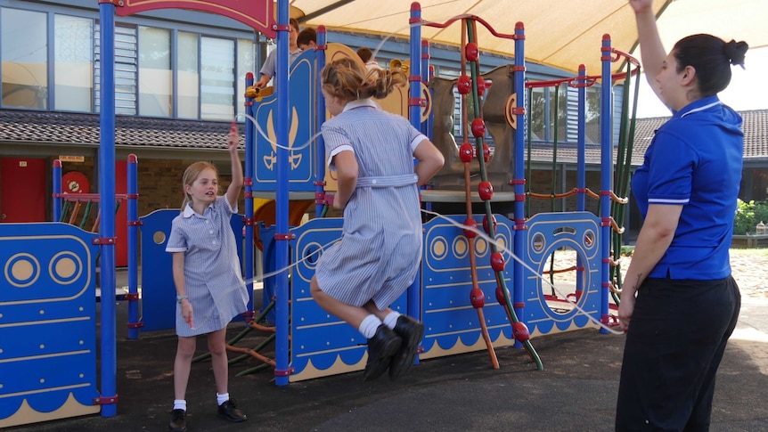 School girls skipping in the playground.