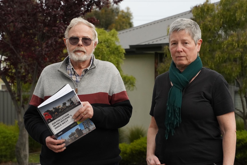 Bert Boere holding an air pollution report standing next to Chair of the group Carmen Largaiolli.