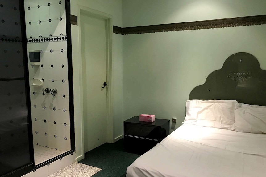 A bed adjacent to a shower at the Wellbeing Planet.