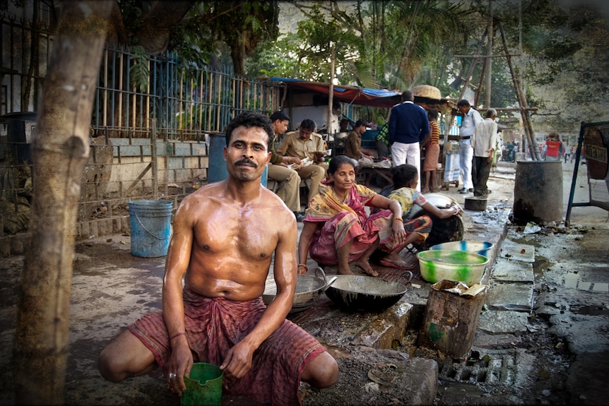 Man washes on the street in India