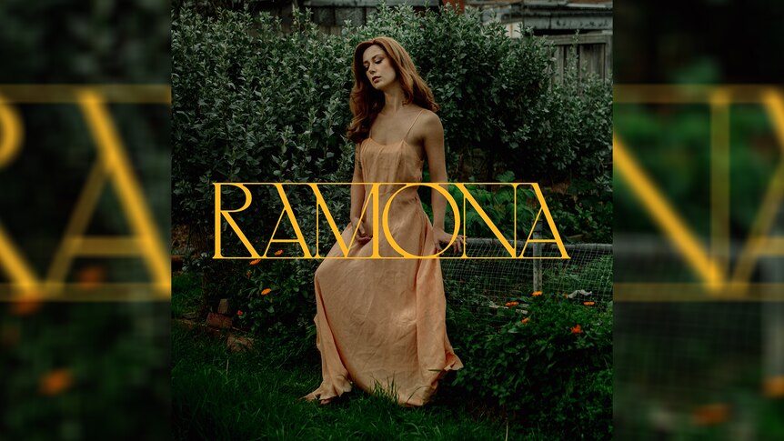 Artwork for Grace Cummings' 2024 album Ramona: stands in silk dress by a hedge with title embossed in gold