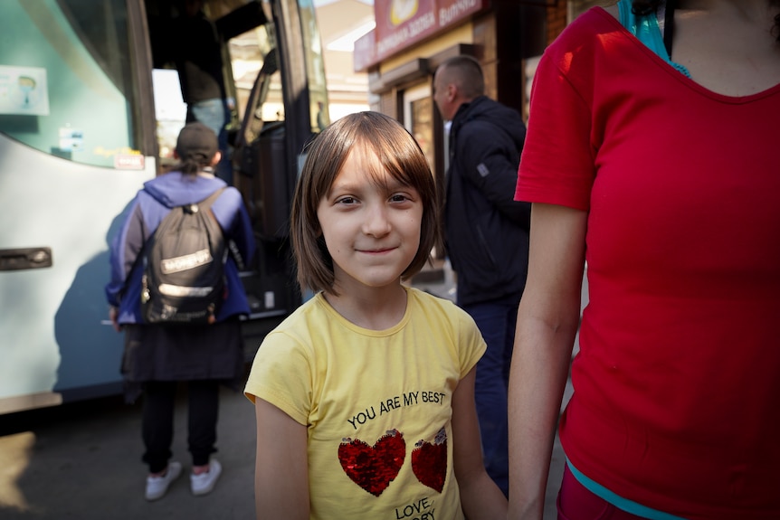 A young girl wears a shirt with red sequin hearts 