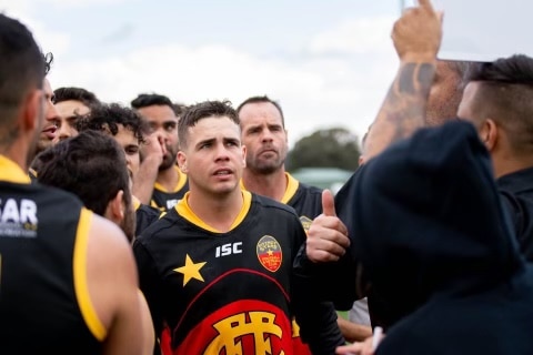 AFL players in a team huddle during a match