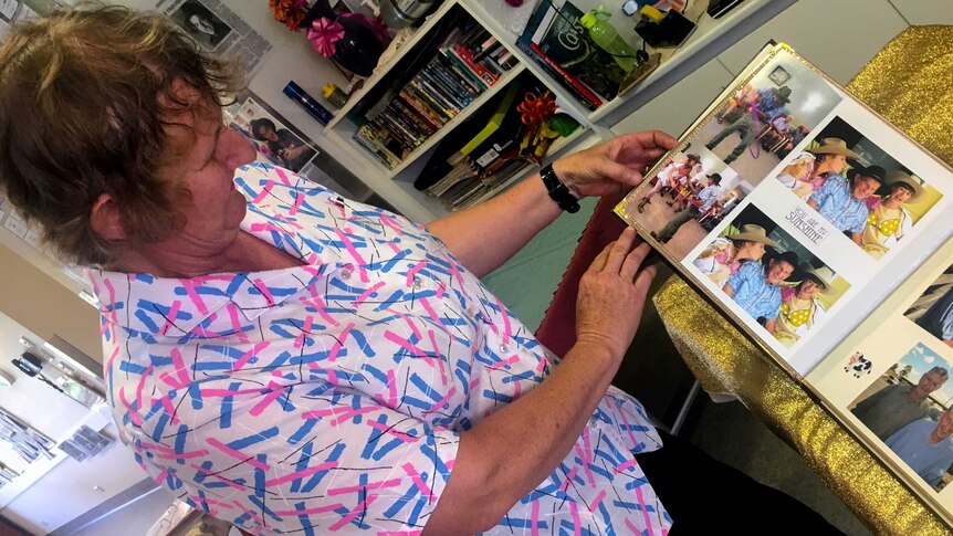 An aged care worker looks down at a photo book