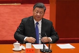 Xi Jinping sitting down before speaking at the Great Hall of the People. 
