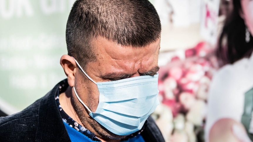 A man wearing a mask covering his eyes