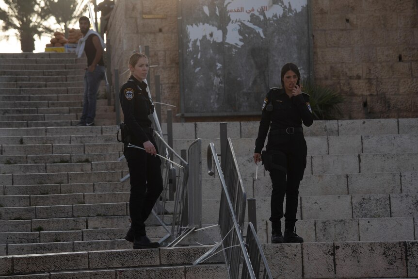 Two police officers fortify fencing leading to the Damascus Gate