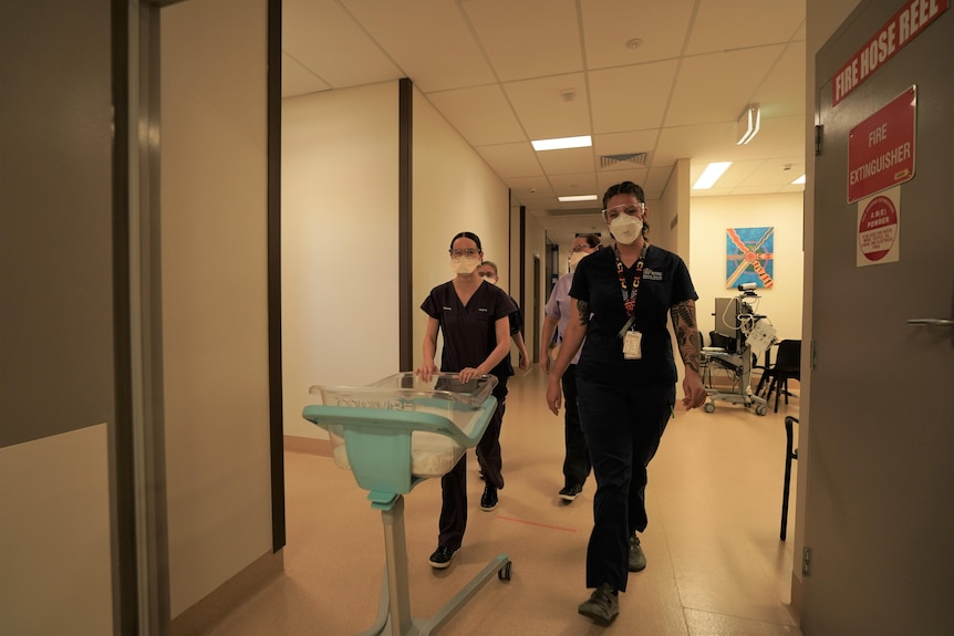 Midwives walk through a hospital corridor 