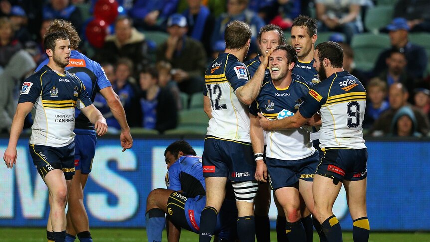 Bonus point ... Zack Holmes and his team-mates celebrate scoring the Brumbies' fourth try
