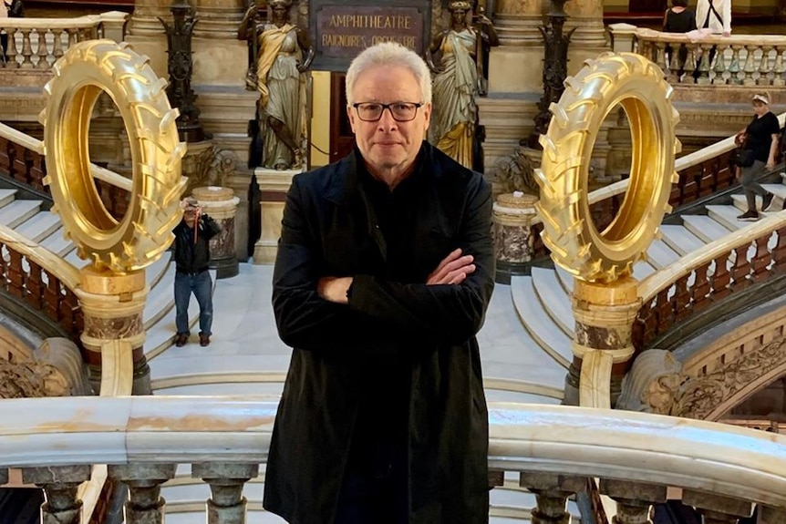 A man standing in an ornate marble staircase