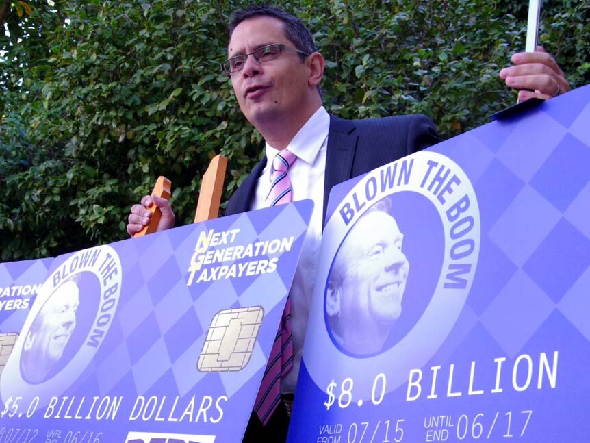 Ben Wyatt with credit card placards on budget debt