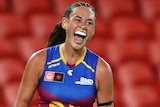 A Brisbane Lions AFLW player celebrates kicking a goal against the Adelaide Crows.