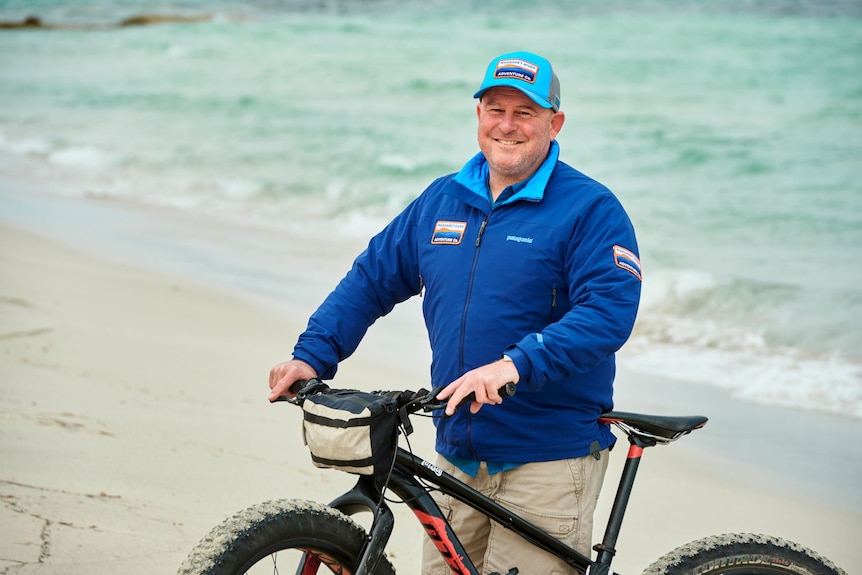 Cam O'Beirne with a bike on the beach