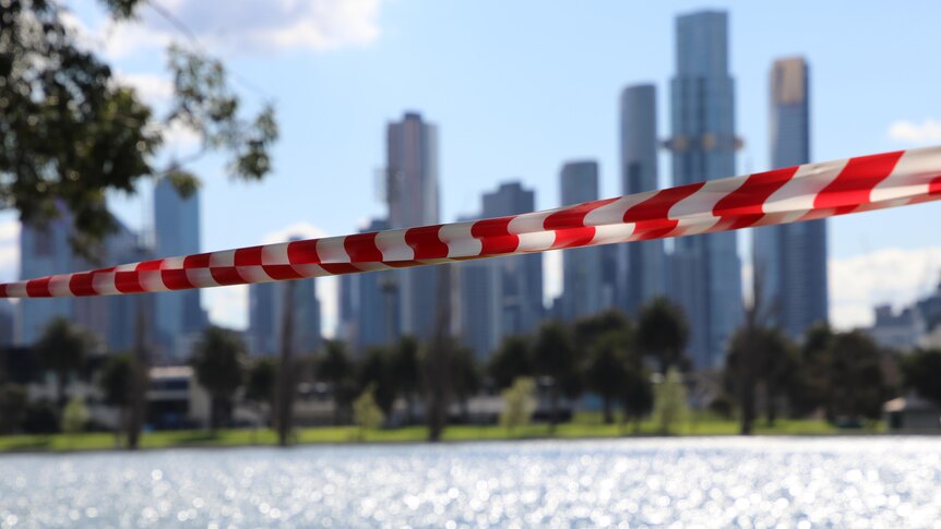 A photo of Melbourne's CBD behind a red and white tape.
