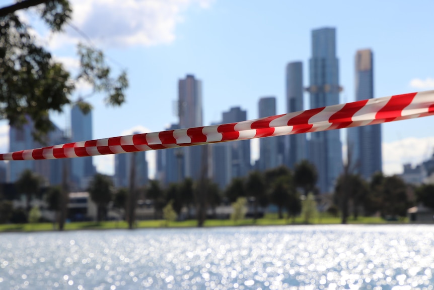 A photo of Melbourne's CBD behind a red and white tape.