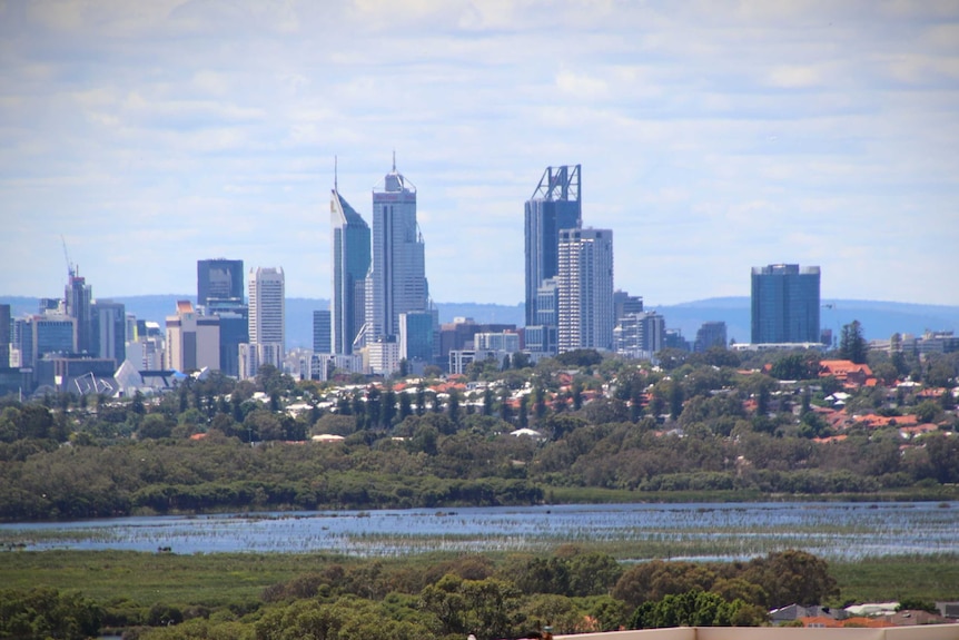 Perth city skyline viewed from a hill with a lake in the foreground