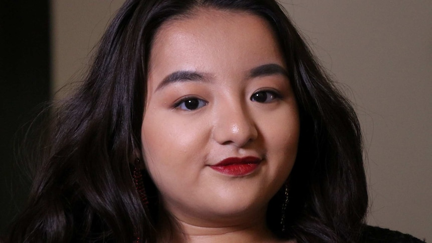 A close up of female choir member Phuong Anh Nguyen wearing red lipstick.