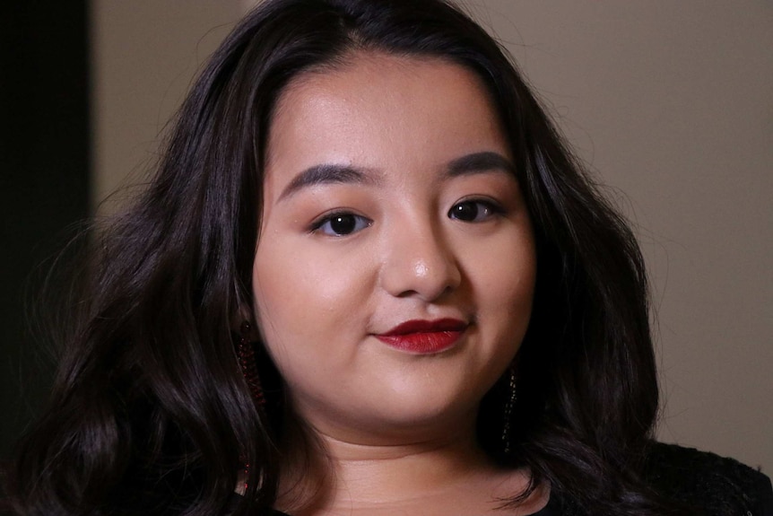 A close up of female choir member Phuong Anh Nguyen wearing red lipstick.