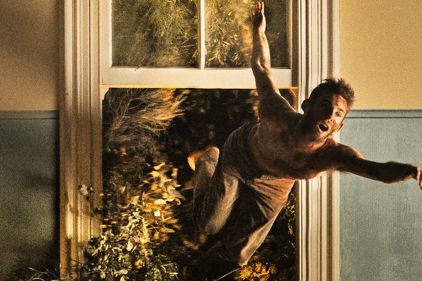 A promotional image of a male dancer dancing in front of open window