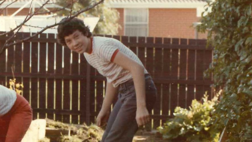 A photo of a young Brendan Sokaluk leaning over wearing long pants and a shirt