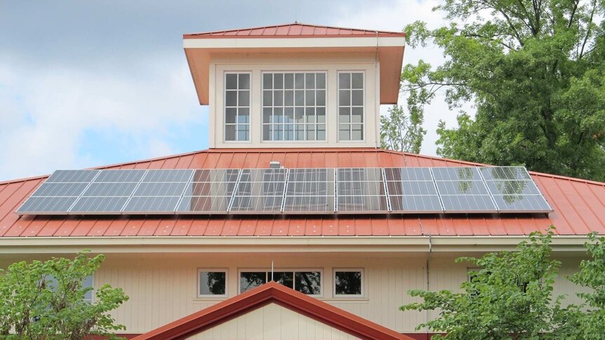 Solar panels on the roof of a large house.