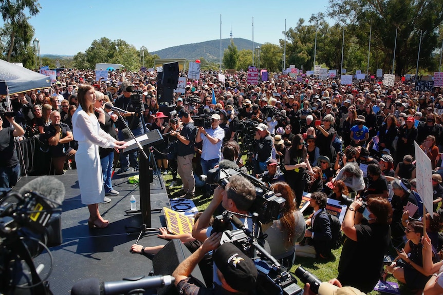 Brittany Higgins speaks in front of a large crowd.