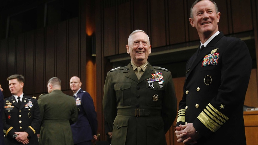 Two men dressed in highly decorated formal military attire smile as they look out to the left of the photographer