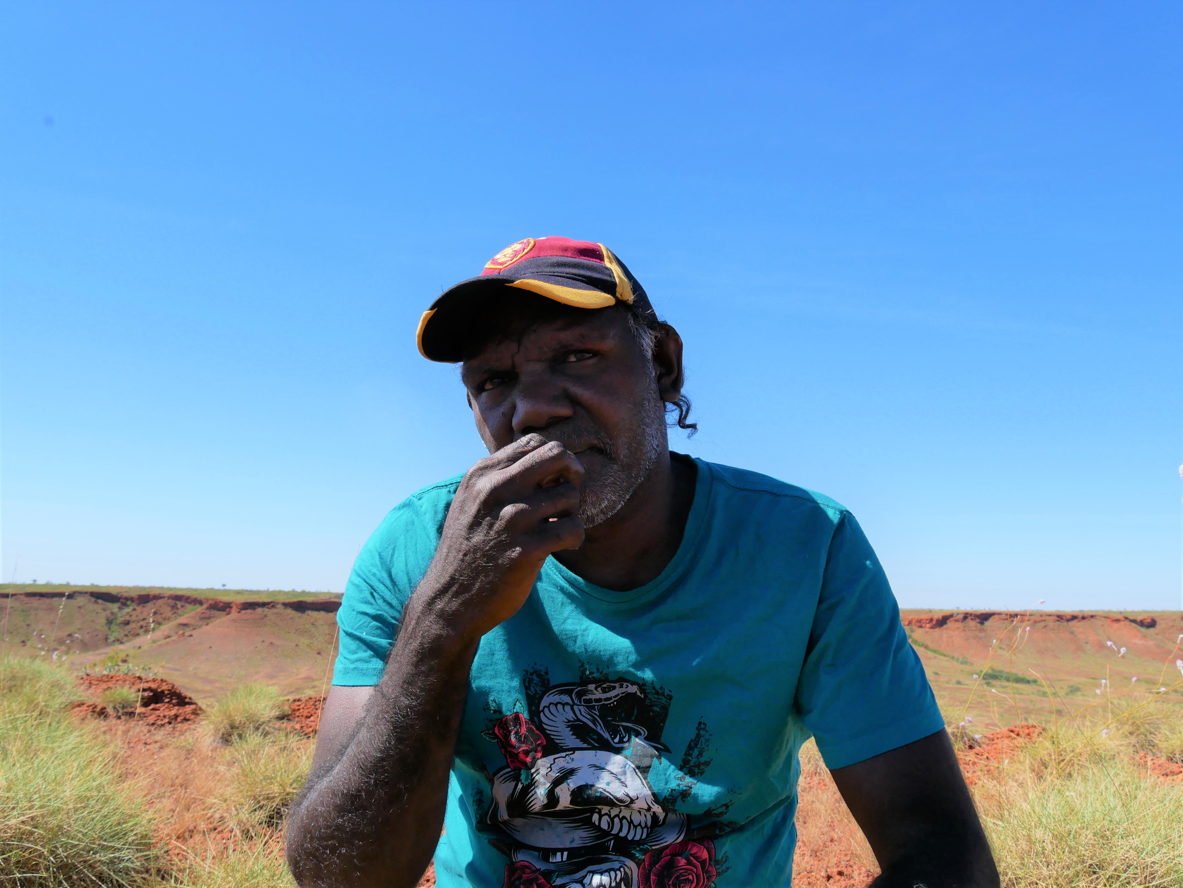 Eric Moora sits on Country in Balgo