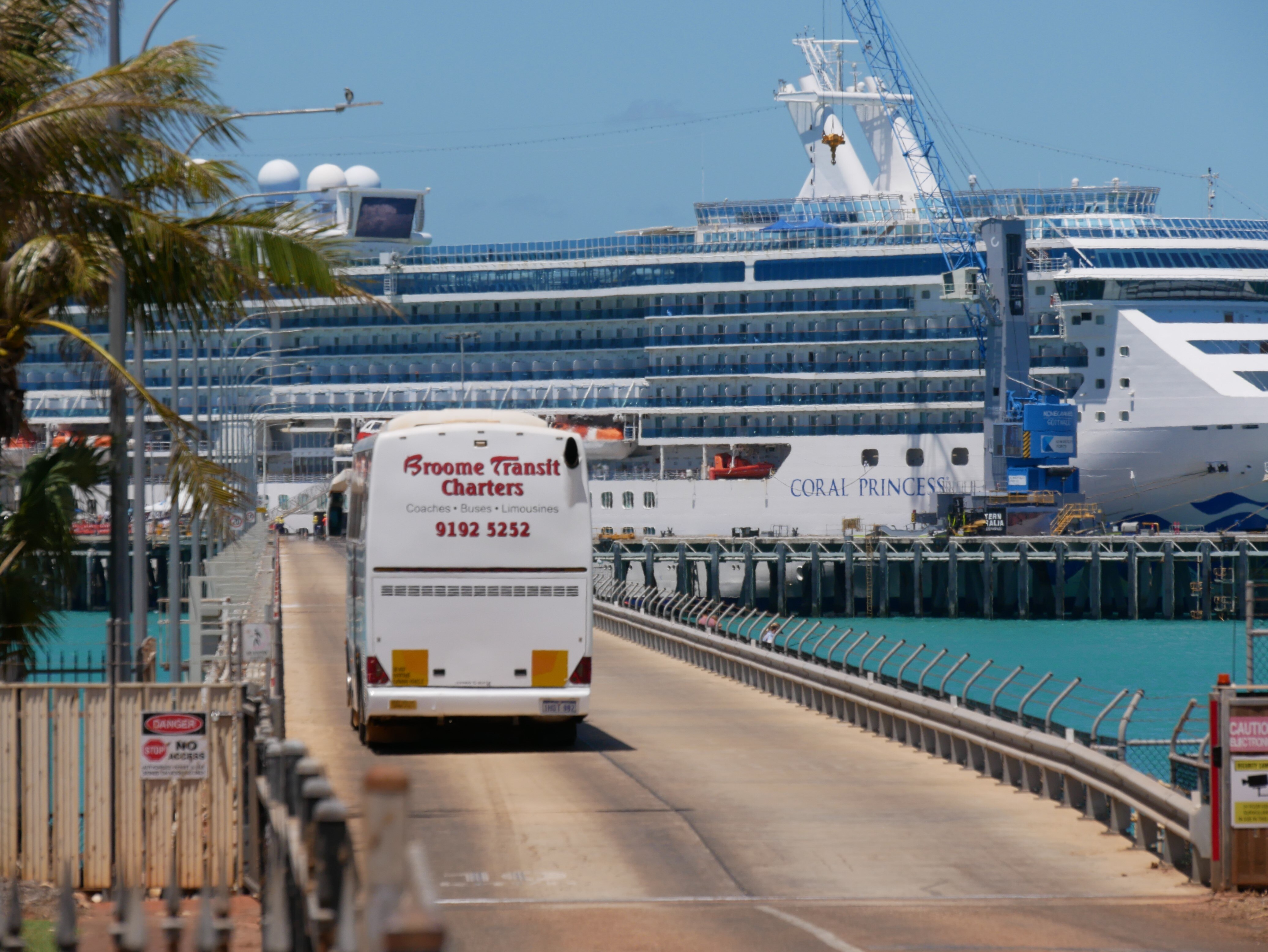 Image of a large tour bus running down the jetty at Broome . Harbor
