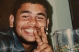 An old colour photo of a young man doing a peace sign with his fingers