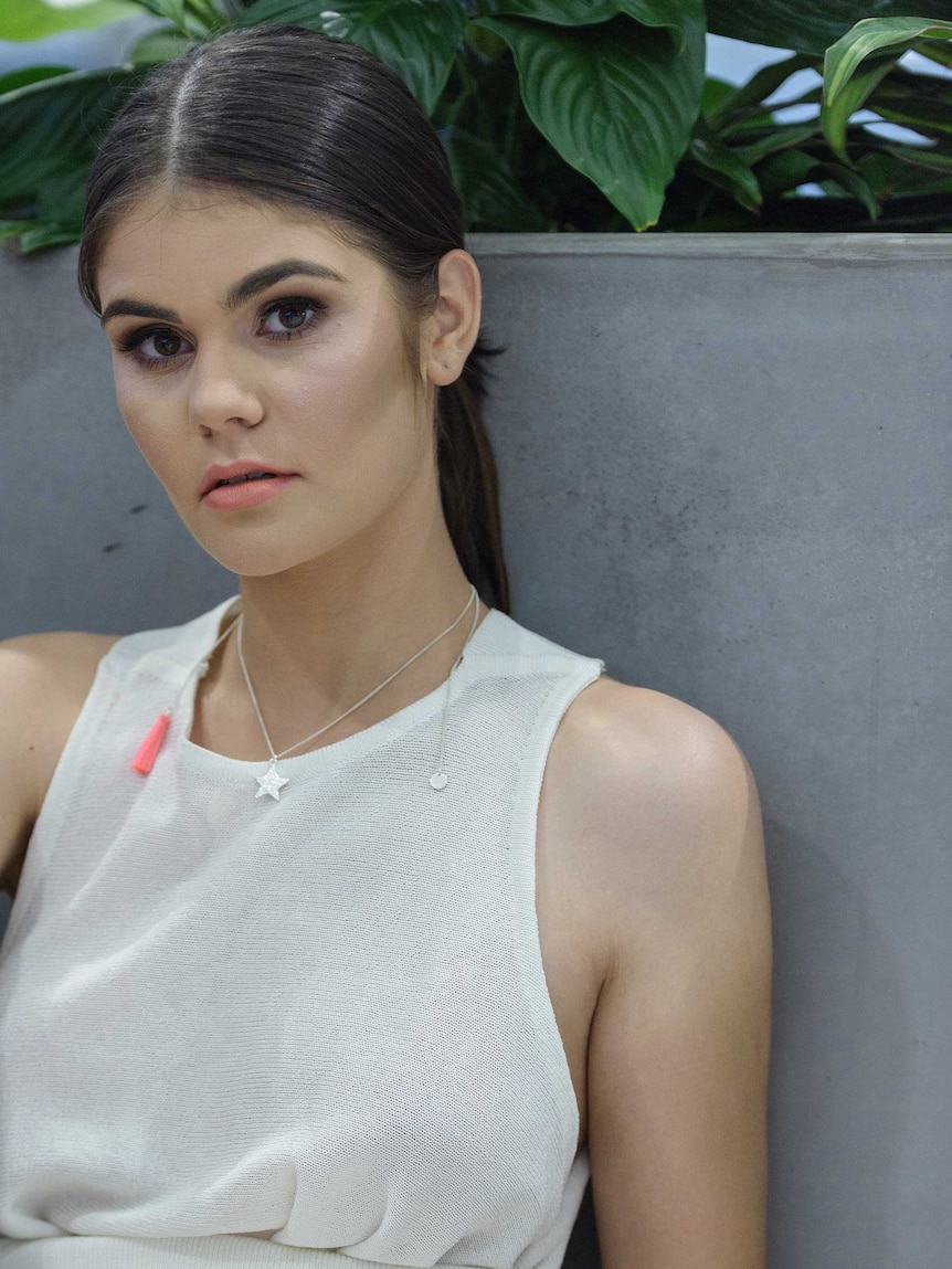 A model poses wearing a star shaped necklace