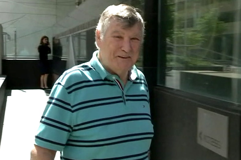 A man in a green striped t-shirt outside court.