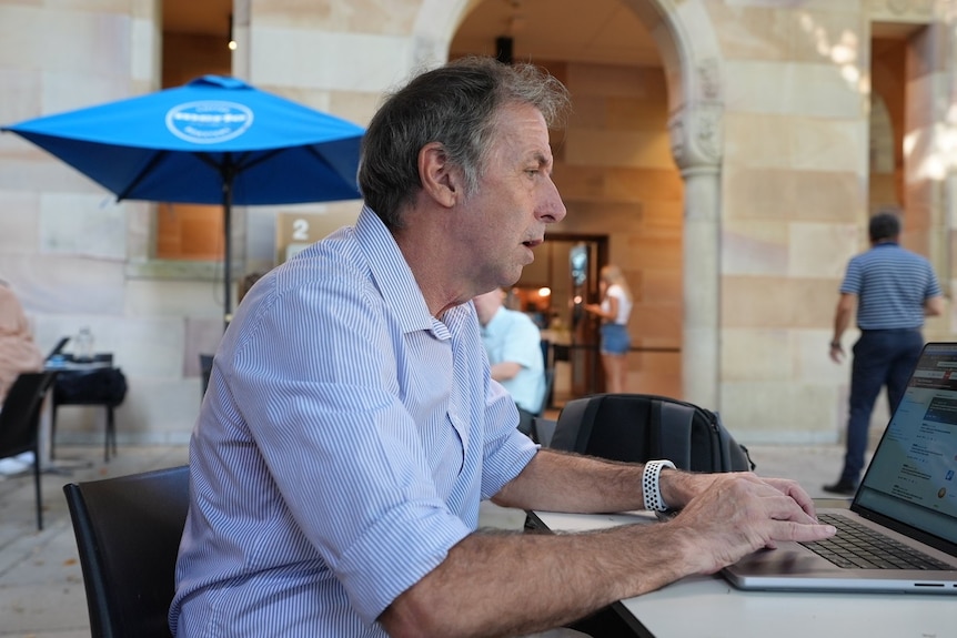 John Quiggin, économiste de l'Université du Queensland, devant son ordinateur portable.