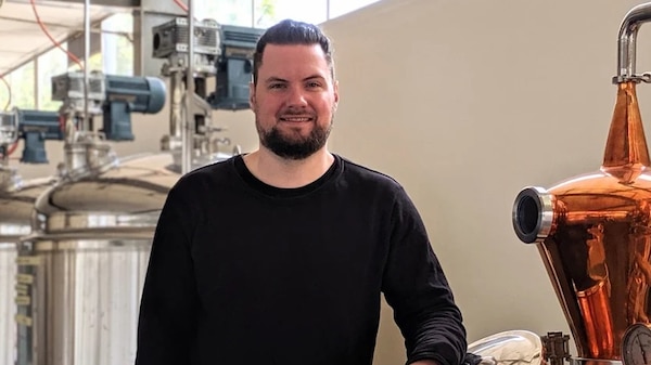 Tarrant Derksen posing for a photo in a rum distillery.