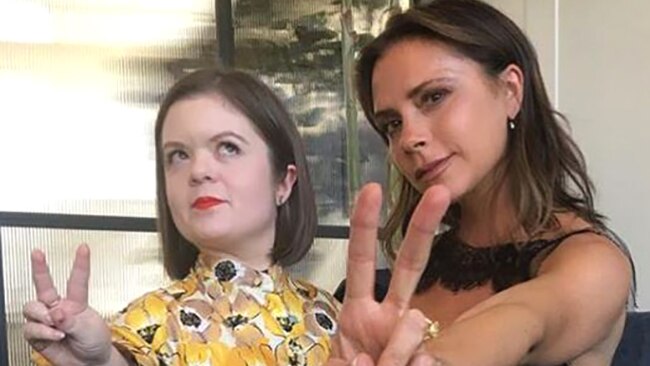 Sinead Burke with Victoria Beckham hold up the victory sign with their fingers.