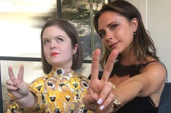 Sinead Burke with Victoria Beckham hold up the victory sign with their fingers.