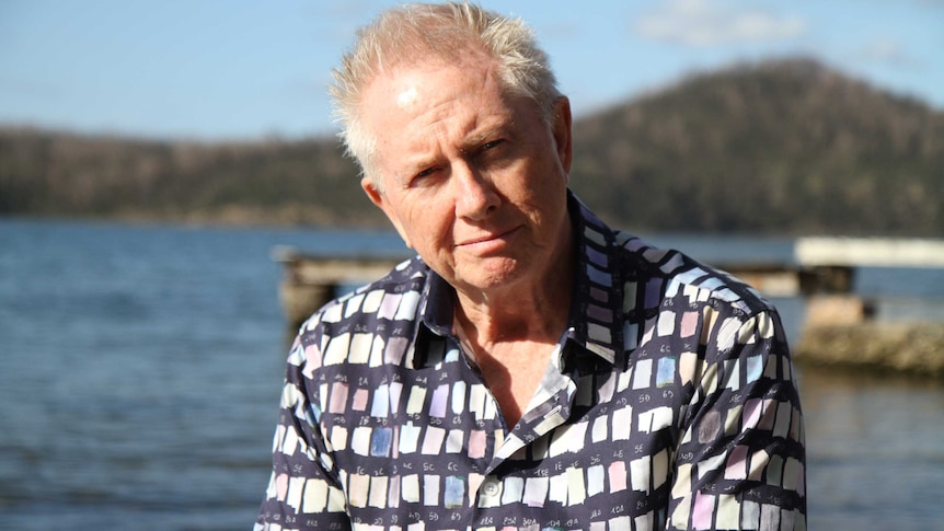 A man looking at the camera in an outdoor setting