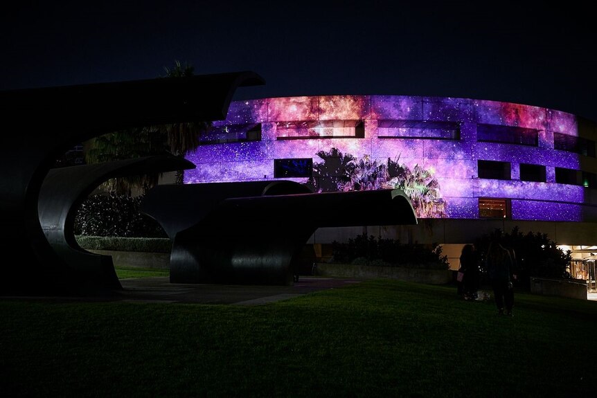 A projection by the artists Maree Clarke and Mitch Mahoney on a purple cosmos onto Hamer Hall