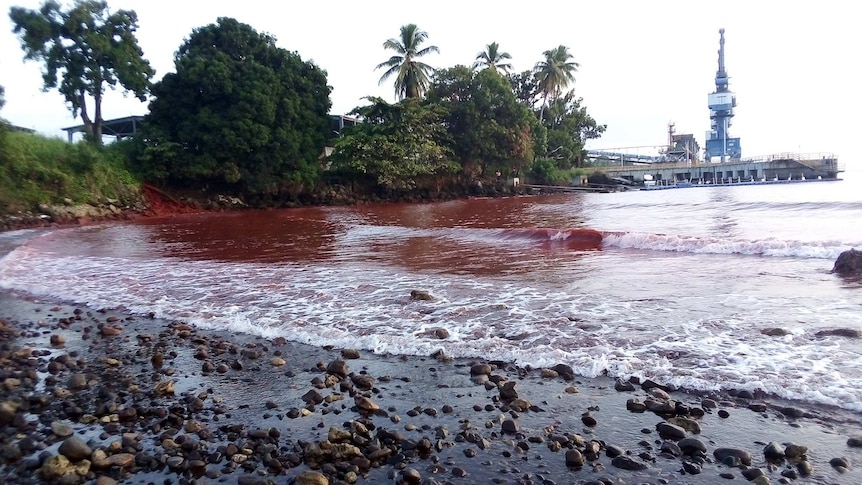 Red water at PNG's Basamuk Bay, following a slurry spill at a Chinese-owned nickel plant, which is in the background.