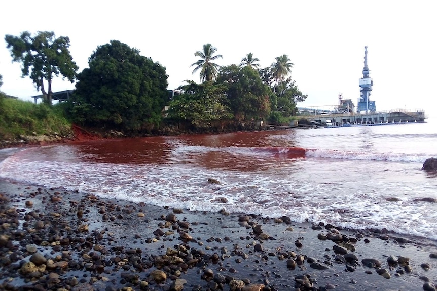 Red water at PNG's Basamuk Bay, following a slurry spill at a Chinese-owned nickel plant, which is in the background.