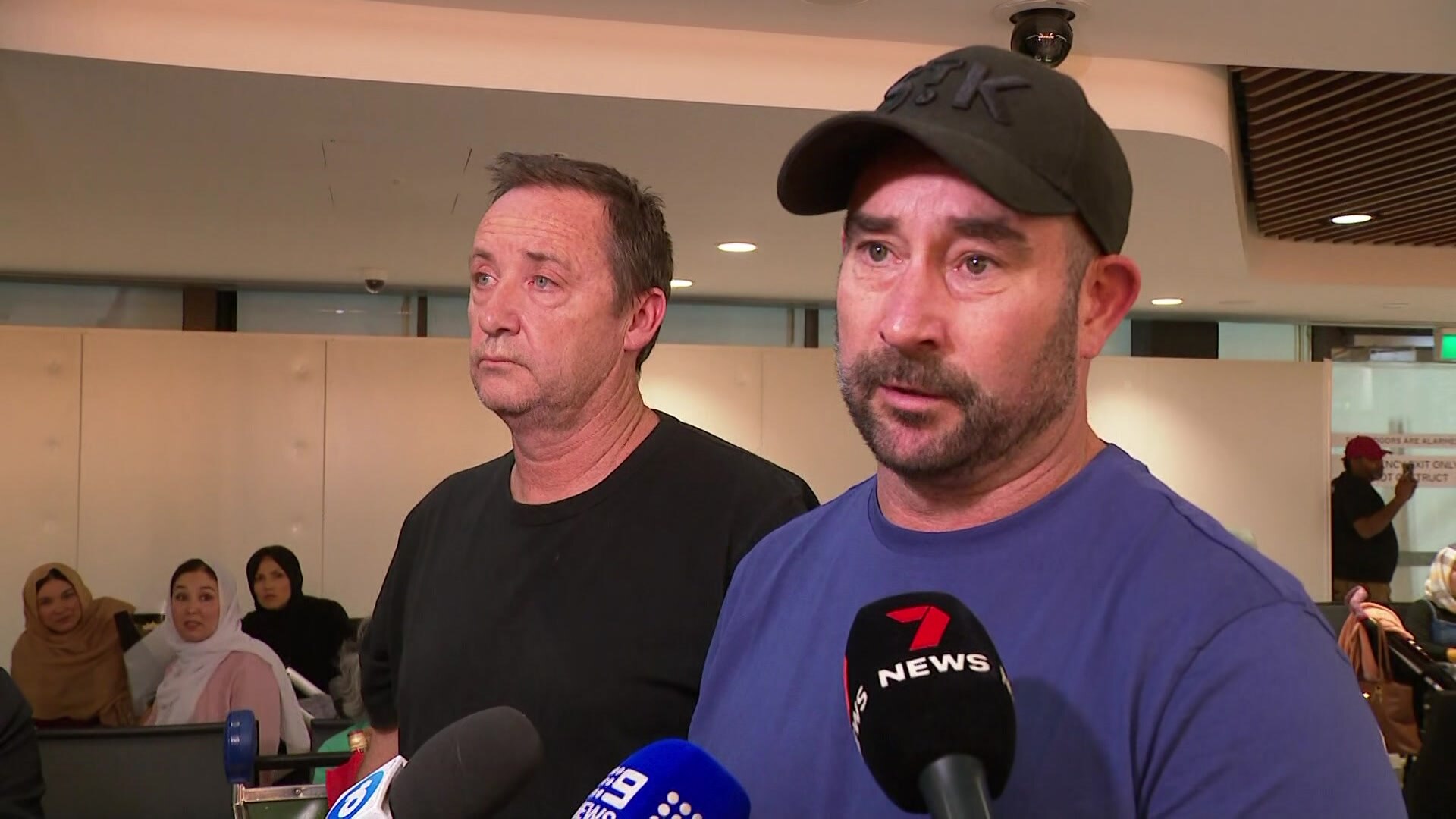 Two men talking to media.