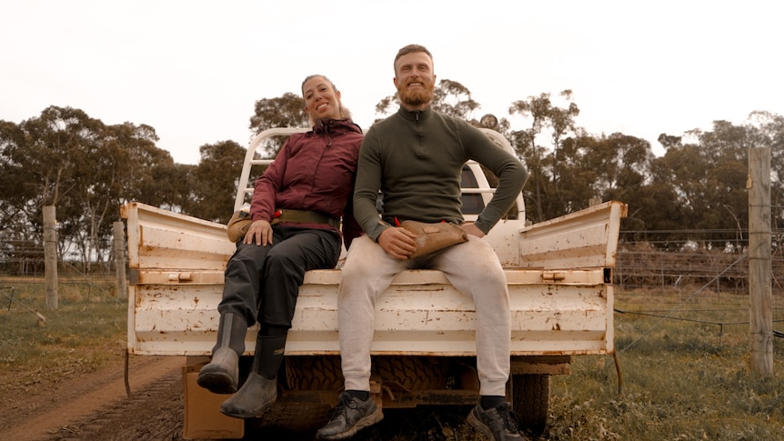 two people sitting in a ute tray