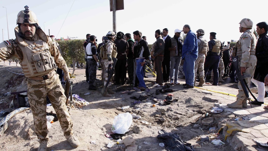 Security forces inspect bomb site in Iraq