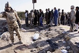 Security forces inspect bomb site in Iraq