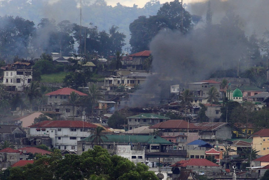 Smokes rises above besieged Marawi City in the distance