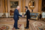 king charles and rishi sunak shake hands in sitting room