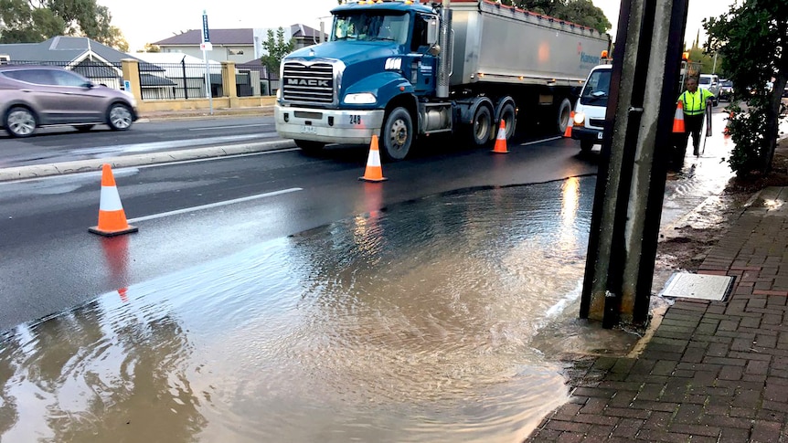 Flooding from a burst water main covers a road.
