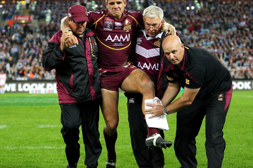 Cory Parker of the Maroons is helped off the field after an injury during game two of the ARL State of Origin
